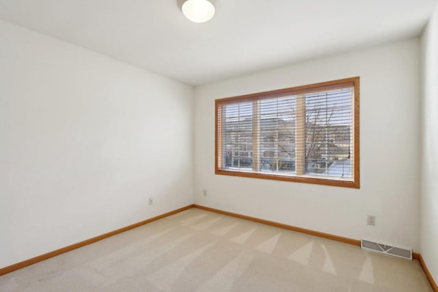 spare room featuring light colored carpet