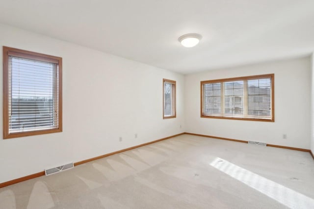 spare room with a healthy amount of sunlight and light colored carpet