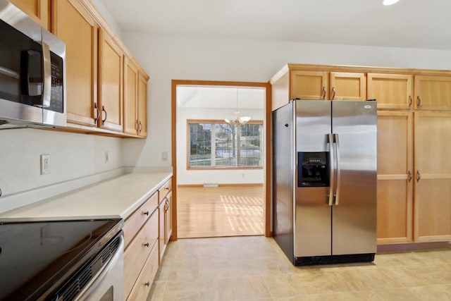 kitchen with pendant lighting, stainless steel appliances, light brown cabinetry, and an inviting chandelier