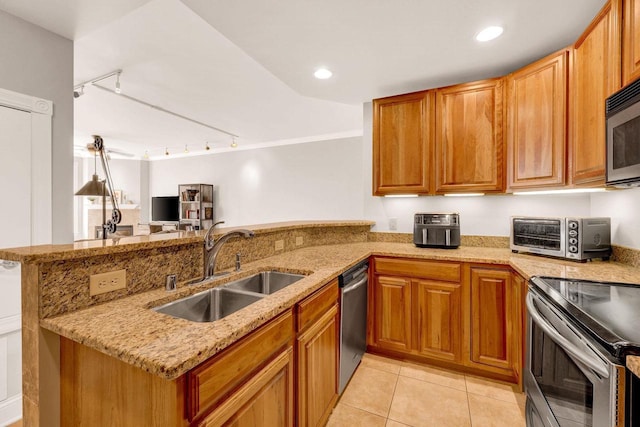 kitchen with track lighting, sink, light stone countertops, light tile patterned flooring, and kitchen peninsula