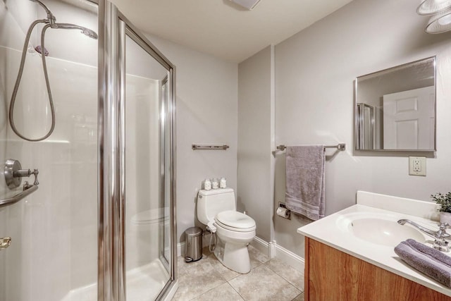 bathroom featuring toilet, vanity, tile patterned floors, and a shower with shower door