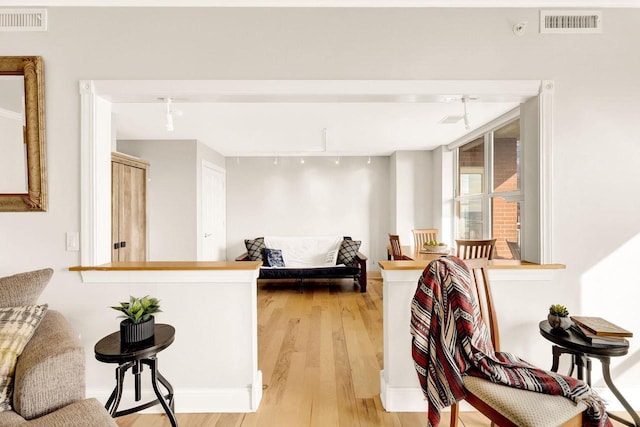 interior space with a kitchen breakfast bar, kitchen peninsula, and light hardwood / wood-style floors