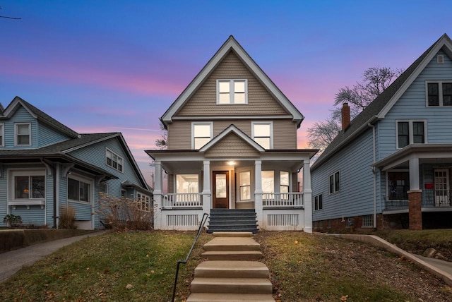 view of front of house with a porch and a yard