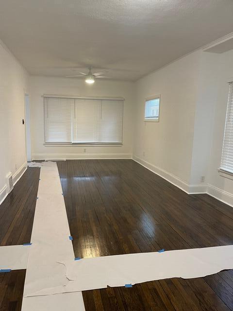 unfurnished room with ceiling fan and dark wood-type flooring