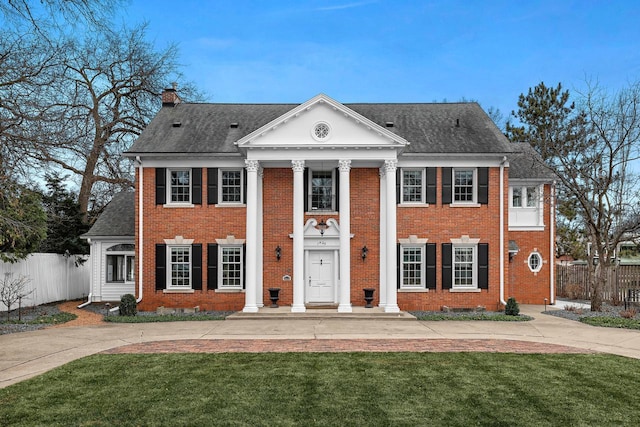 greek revival house featuring a front yard