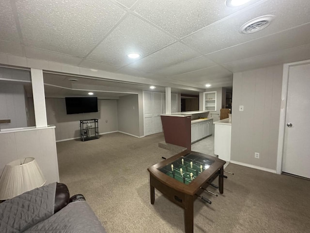 living room featuring light carpet and a paneled ceiling