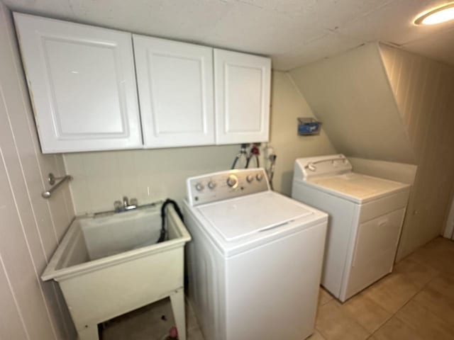 laundry area featuring cabinets, independent washer and dryer, sink, and light tile patterned floors