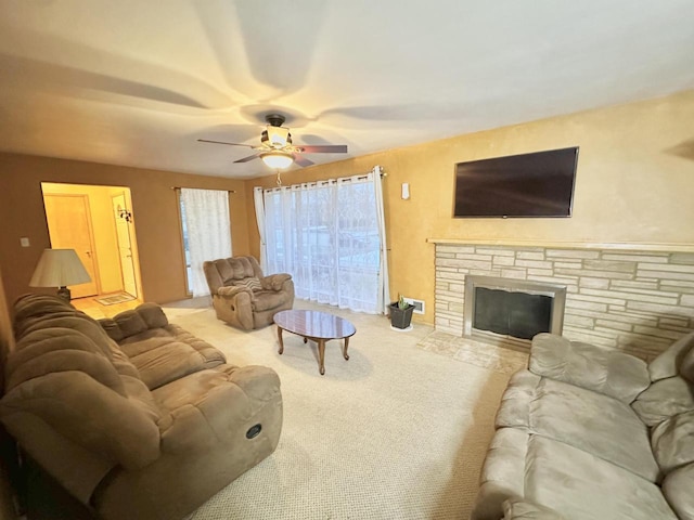 living room featuring ceiling fan, a fireplace, and light colored carpet