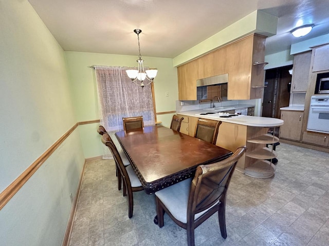 dining room with sink and a chandelier