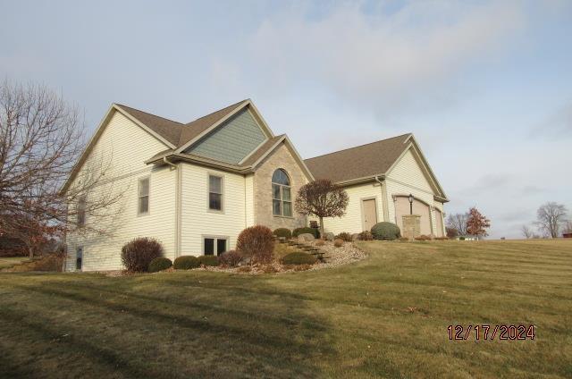 view of side of home featuring a garage and a yard