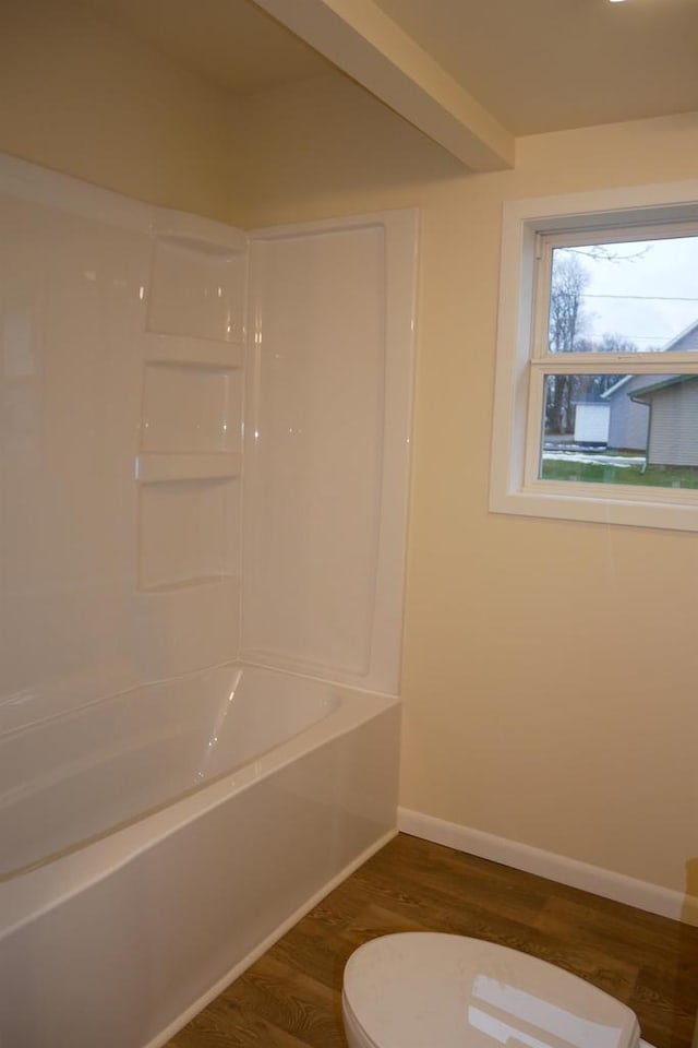 bathroom featuring hardwood / wood-style floors,  shower combination, and toilet