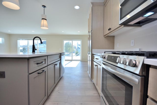 kitchen featuring gray cabinetry, a center island, decorative light fixtures, sink, and appliances with stainless steel finishes