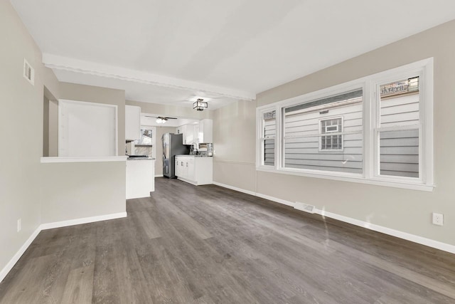 unfurnished living room with dark hardwood / wood-style floors and ceiling fan