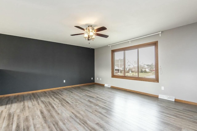 empty room featuring hardwood / wood-style flooring and ceiling fan