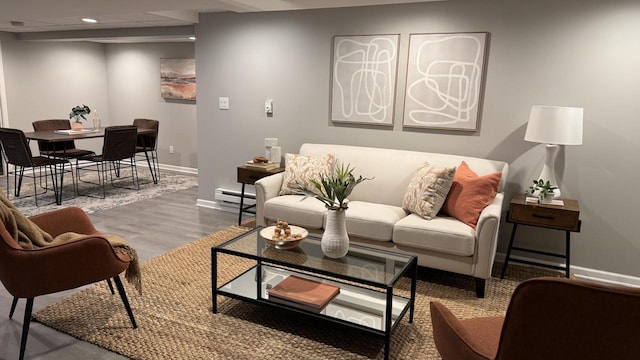 living room with wood-type flooring and a baseboard heating unit