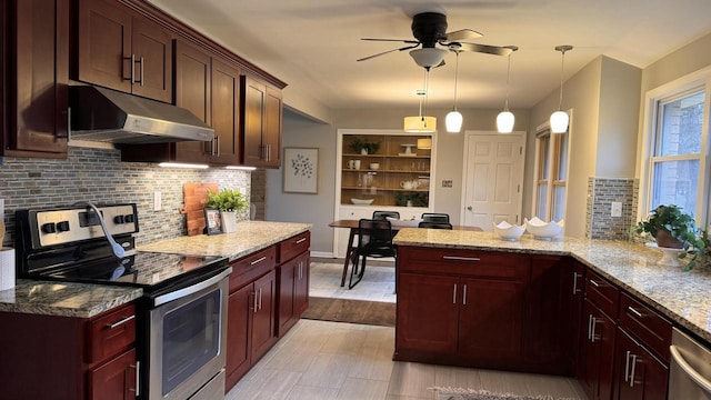 kitchen with kitchen peninsula, appliances with stainless steel finishes, light stone counters, ceiling fan, and hanging light fixtures