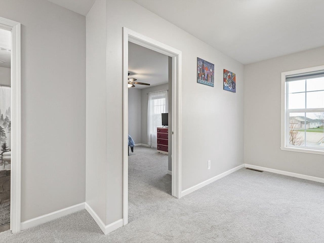 empty room featuring light colored carpet and ceiling fan