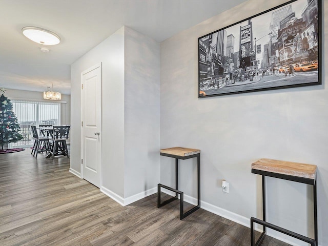 hallway with a notable chandelier and wood-type flooring