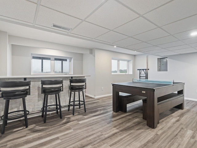 rec room featuring hardwood / wood-style floors, a paneled ceiling, and electric panel