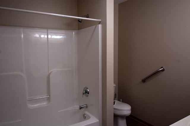 bathroom featuring tub / shower combination and toilet