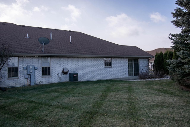 rear view of house with a yard and central air condition unit