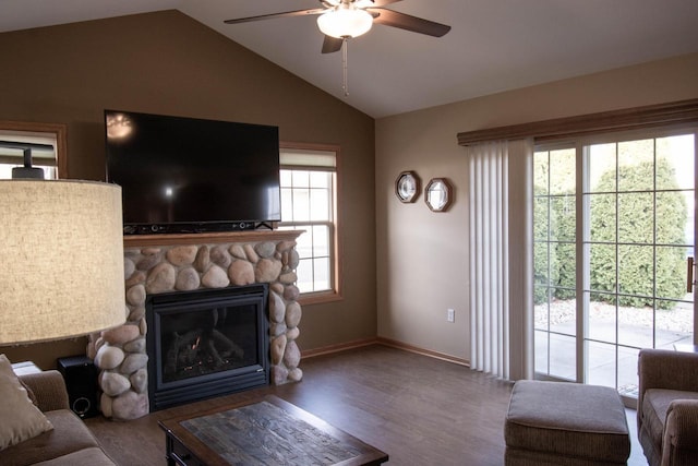 living room featuring ceiling fan, wood-type flooring, a fireplace, and vaulted ceiling