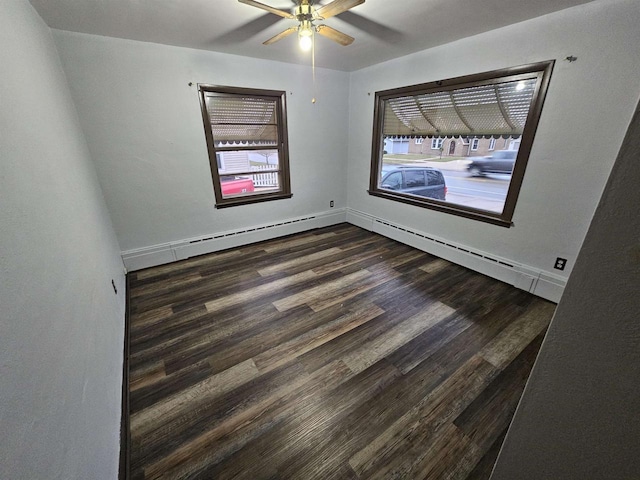 unfurnished room featuring ceiling fan, dark hardwood / wood-style flooring, and a baseboard heating unit