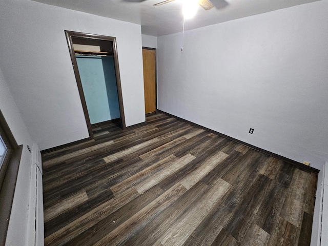 unfurnished bedroom with a closet, dark hardwood / wood-style floors, and ceiling fan