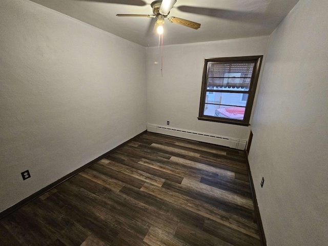 spare room featuring baseboard heating, dark wood-type flooring, and ceiling fan