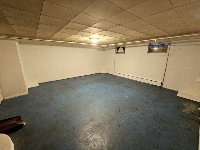 basement featuring baseboard heating and a drop ceiling