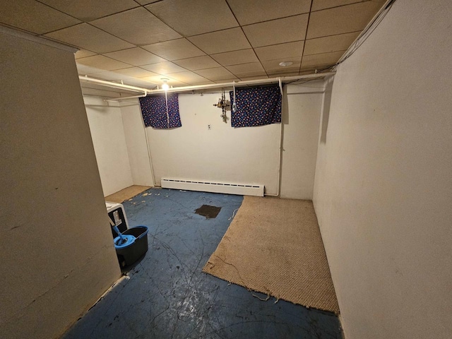 basement featuring a drop ceiling and baseboard heating