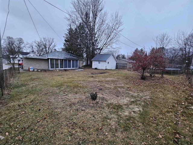 view of yard with a trampoline and a sunroom