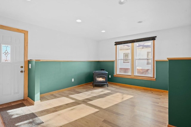 foyer with hardwood / wood-style floors and a wood stove