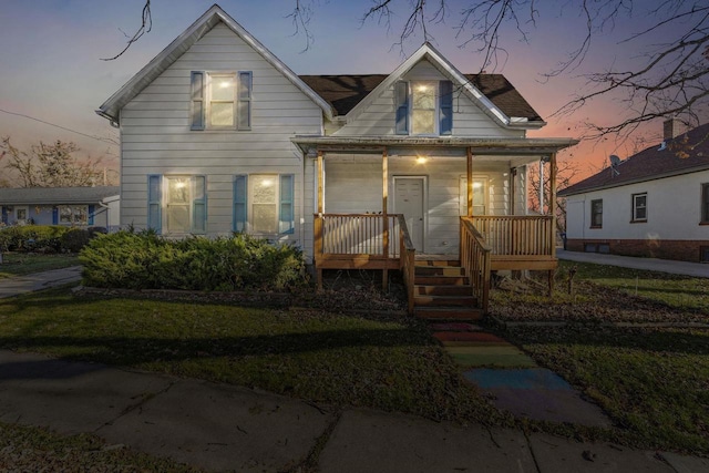 bungalow-style house with a lawn and covered porch