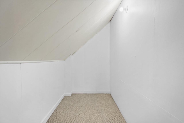 bonus room featuring light carpet and vaulted ceiling