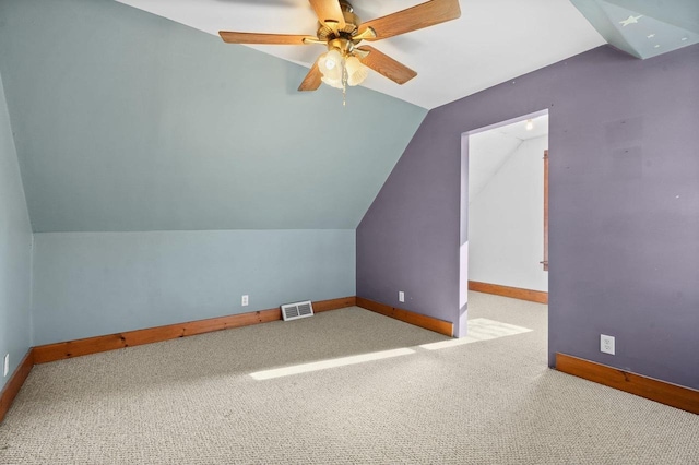 additional living space with ceiling fan, light colored carpet, and vaulted ceiling