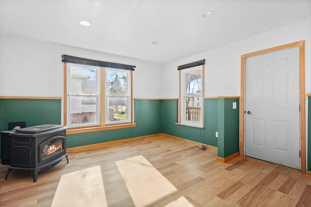 interior space with a wood stove and hardwood / wood-style floors