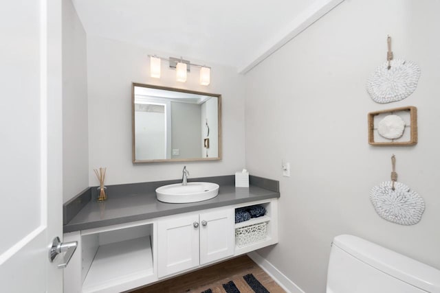 bathroom with hardwood / wood-style flooring, vanity, and toilet