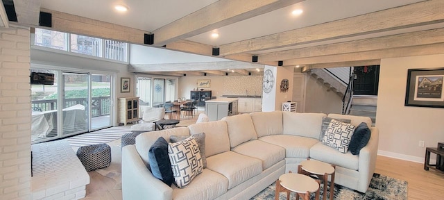 living room with beam ceiling and light wood-type flooring