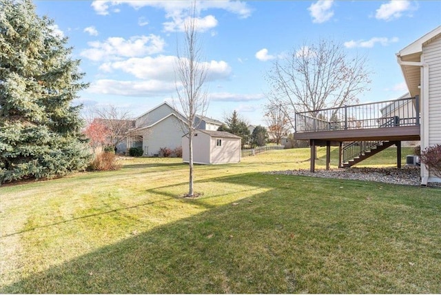 view of yard with a shed, central AC unit, and a wooden deck