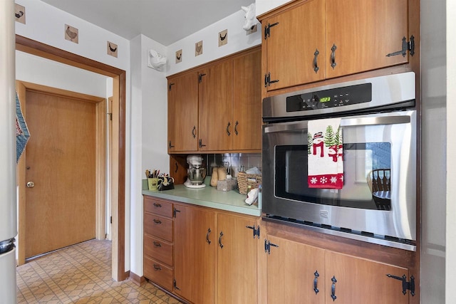 kitchen with decorative backsplash and stainless steel oven