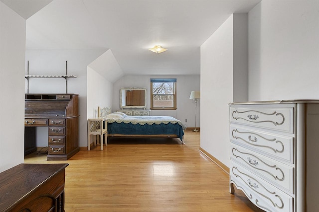 bedroom featuring lofted ceiling and light wood-type flooring