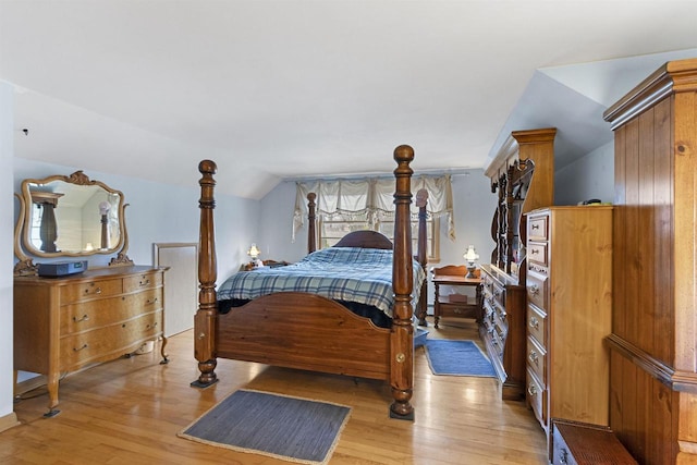 bedroom featuring light wood-type flooring and vaulted ceiling