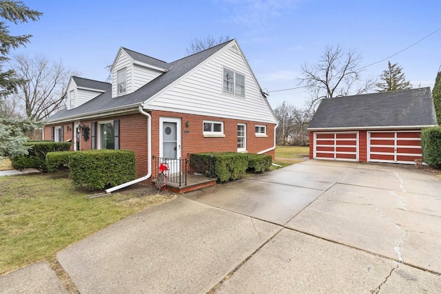 cape cod house with an outbuilding, a garage, and a front yard