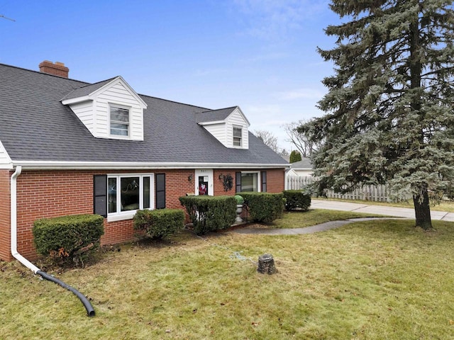 cape cod house with a front yard