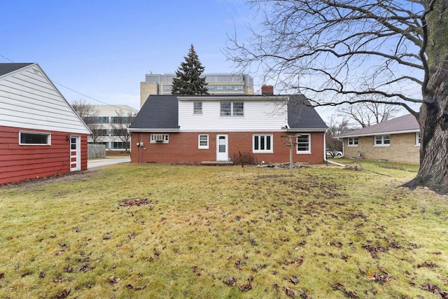 rear view of house featuring a lawn and a wall unit AC