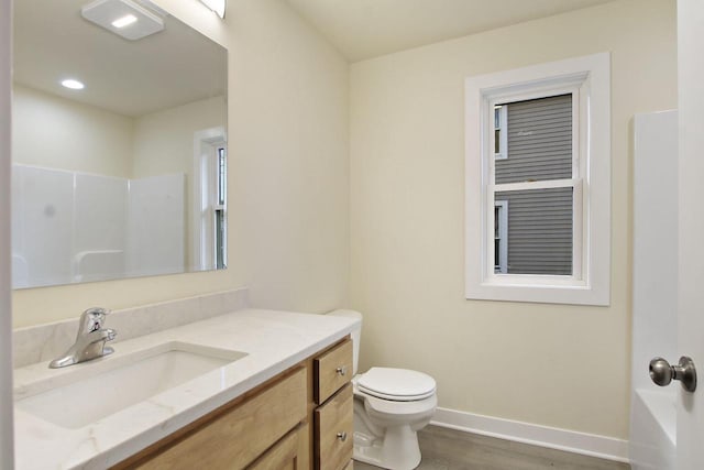 bathroom with a shower, toilet, vanity, and hardwood / wood-style flooring