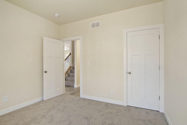 unfurnished bedroom featuring light carpet