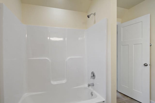 bathroom featuring hardwood / wood-style floors and  shower combination