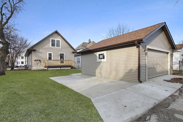 back of property featuring a deck, cooling unit, a garage, and a lawn